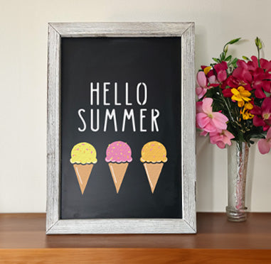 Framed chalkboard sign reading 'HELLO SUMMER' with three colorful ice cream cones, crafted using letter and ice cream cone stencils, displayed next to a vase of flowers