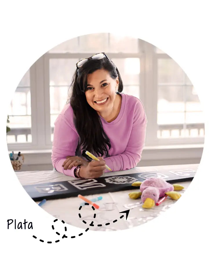 Karen, the Founder of Plata Chalkboards making an outdoor porch chalkboard sign with Plata, her daughters stuffed platypus
