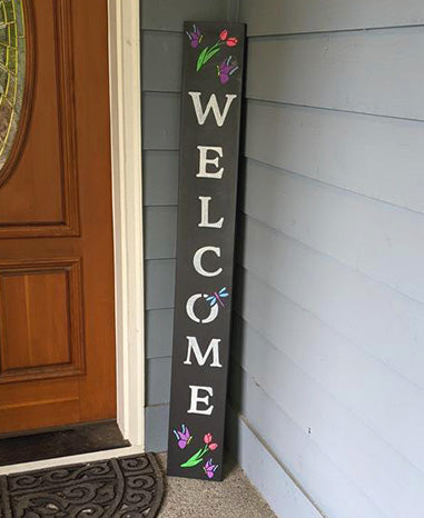 Decorative chalkboard DIY sign saying 'WELCOME' with colorful tulips, crafted using Plata Chalkboards' spring stencils and paint pens, by a front door