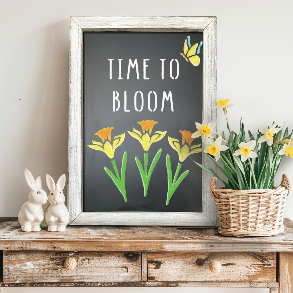 Rustic white framed chalkboard stenciled 'Time to Bloom' using magnetic letter stencils and spring flower stencils to create a spring chalkboard sign