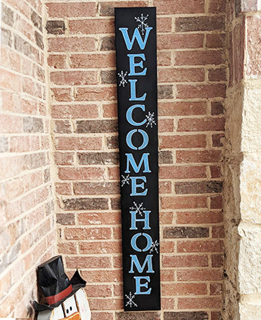 DIY welcome sign chalkboard sign stenciled  'WELCOME HOME' in bold blue letters, decorated with white snowflakes, crafted using magnetic stencil letters and painting pens from Plata Chalkboards