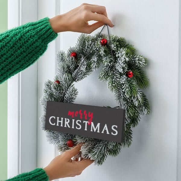 Chalkboard stenciled with letter stencils to craft a Merry Christmas Chalkboard Sign and placed on wreath to create a Merry Christmas wreath sign