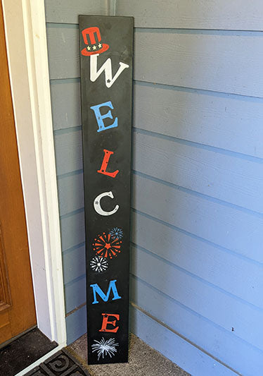 Outdoor DIY welcome sign with 'welcome' in red, white and blue and fireworks stenciled on big chalkboard to create a patriotic home decor