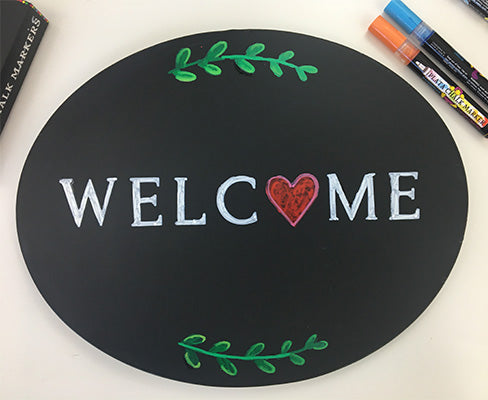 A beautiful Valentines Day chalkboard welcome sign created with easy magnetic chalkboard letter stencils and stencil painting pens to create a DIY sign