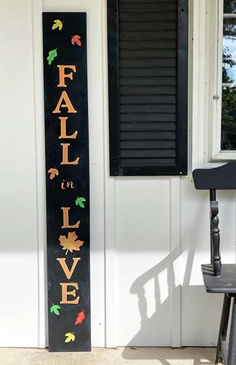 "Fall in Love" Fall farmhouse porch sign crafted from Plata DIY sign kits with a large porch chalkboard, lettering stencils, paint pens and fall leaf stencils to create a personalized door sign