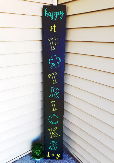 Tall porch sign outdoor chalk board displaying 'Happy St. Patrick's Day' in a creative layout with 'ST PATRICKS' in large green letters vertically aligned and 'happy' and 'day' in smaller text, accented with a shamrock, crafted with chalkboard stencils and chalk paint pens for seasonal outdoor decor