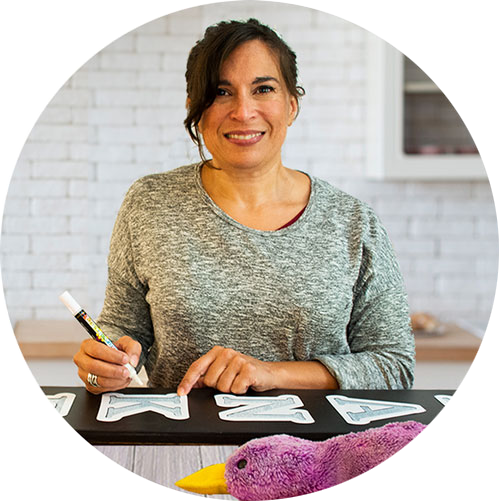 Karen, the Founder of Plata Chalkboards, crafting a chalkboard welcome sign with magnetic letter stencils and erasable paint pens.