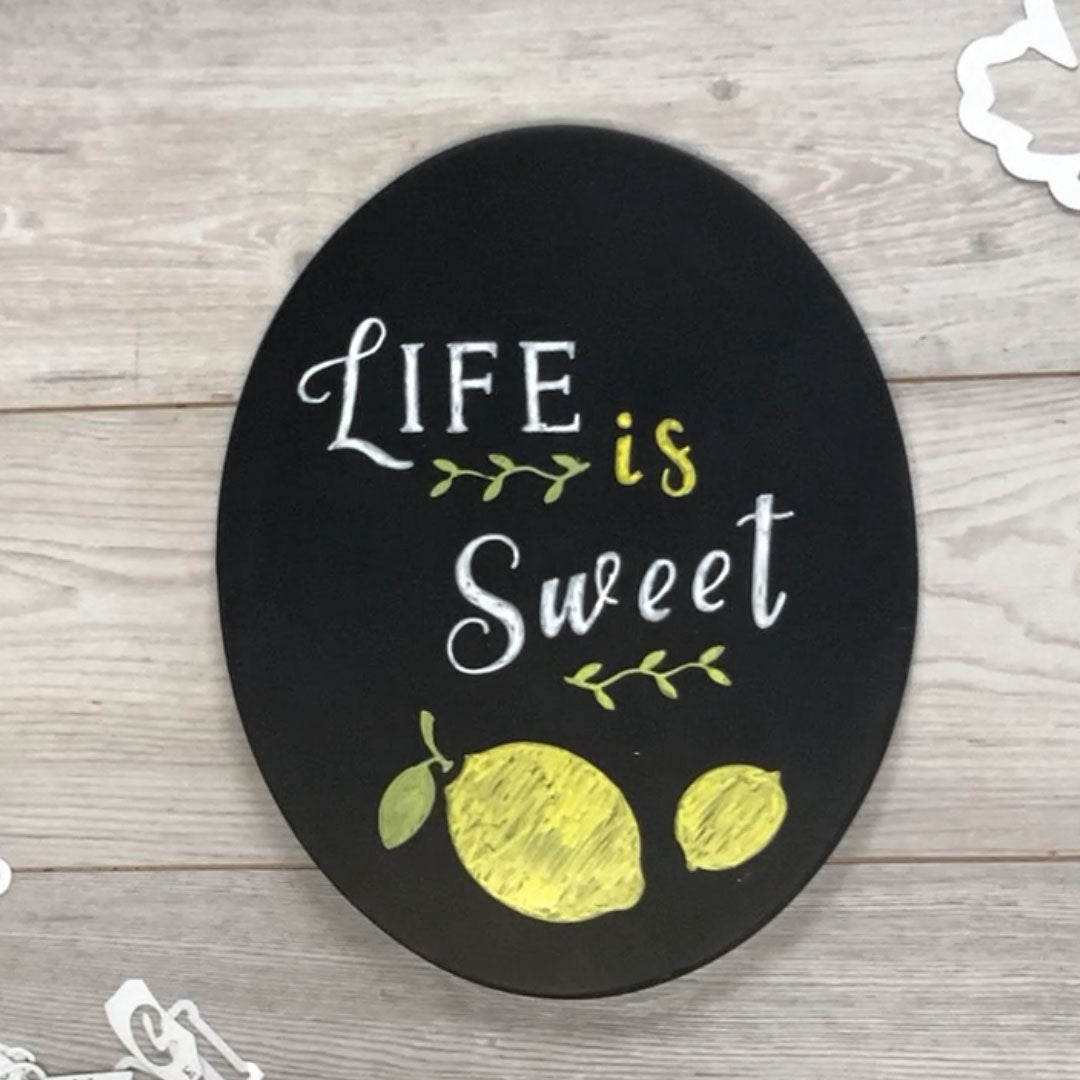 Life is Sweet summer chalk board art crafted on an oval magnetic chalkboard using chalkboard lettering stencils and lemon stencils for DIY summer sign