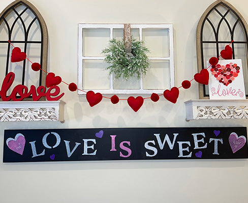Love is Sweet Valentine's Day Chalkboard stenciled on a large chalkboard mounted to wall for custom Valentine's Day decor