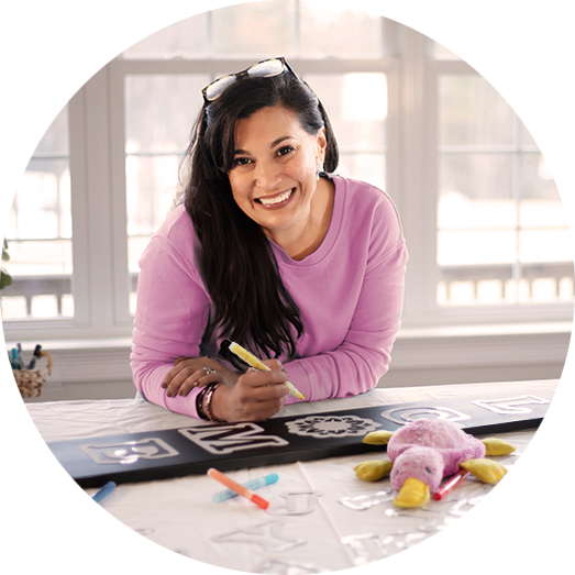 a woman crafting a large outdoor chalkboard with magnetic welcome stencils and liquid chalk markers 