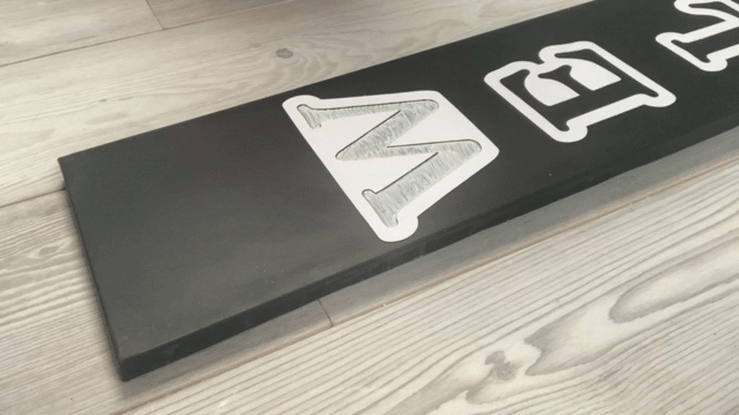 Gif of removing reusable stencil from the board to reveal a stenciled welcome sign for front porch.
