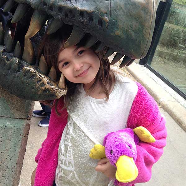 A little girl at a park holding a purple stuffed platypus, the stuffed animal is the inspiration for the name of Plata Chalkboards 