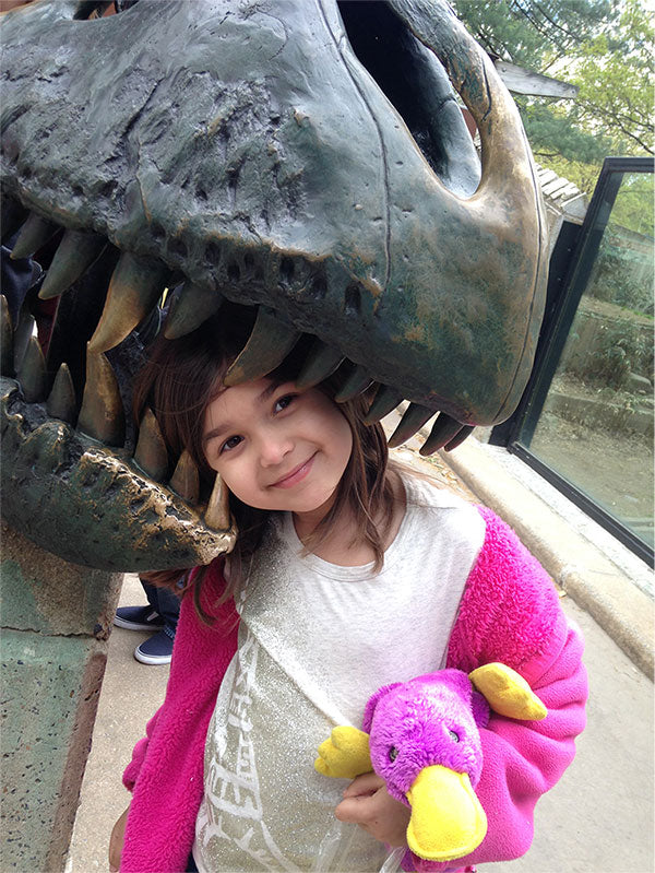 A little girl in a park with the stuffed purple platypus that our company, Plata Chalkboards, was named after