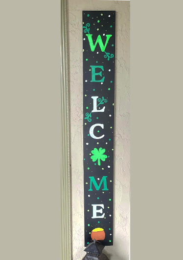 Seasonal welcome sign with 'WELCOME' in vibrant green letters, sprinkled with whimsical swirls and shamrock designs, ideal for St. Patrick's Day entryway decor crafted with letter stencils on a magnetic chalkboard sign