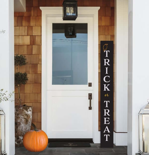 Trick or Treat Tall 5 ft Sign next to front door crafted with halloween stencils on a Plata Porch Chalkboard