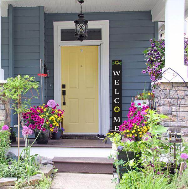 A 5 foot tall welcome sign for front door black chalkboard porch sign with sunflowers crafted with large letter stencils and painting pens.