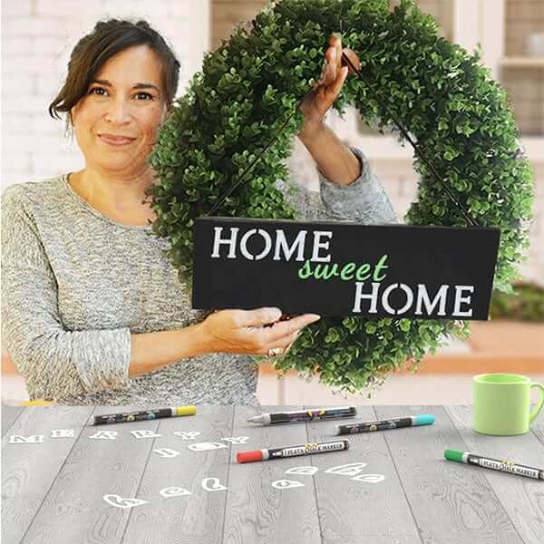 Woman holding Home Sweet Home Wreath accent sign chalkboard crafted with chalkboard stencils for painting